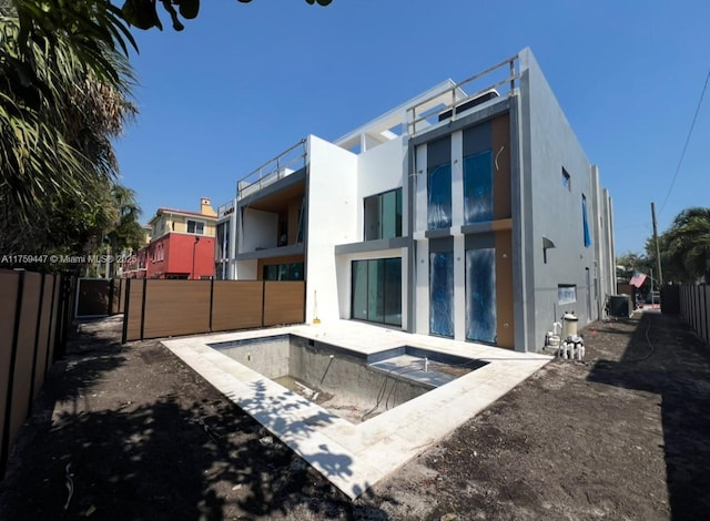 back of house featuring a fenced backyard and stucco siding