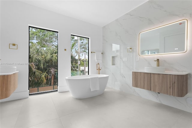 1823 NE 26th Ave, Fort Lauderdale, FL 33305 - bathroom with a freestanding tub, tile walls, tile patterned flooring, and vanity