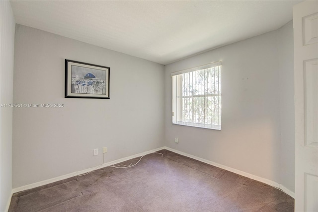 spare room featuring carpet floors and baseboards