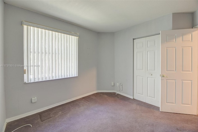 unfurnished bedroom featuring carpet, baseboards, and a closet