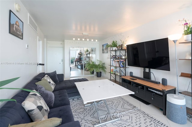 living room featuring light tile patterned flooring and visible vents