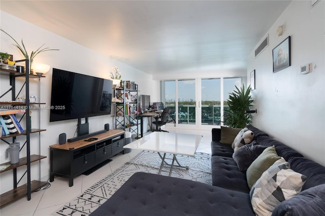 living room featuring light tile patterned floors, floor to ceiling windows, and visible vents