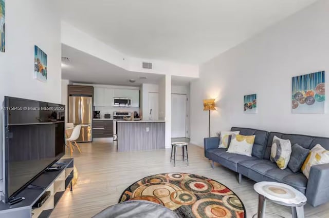 living area featuring light wood-type flooring and visible vents