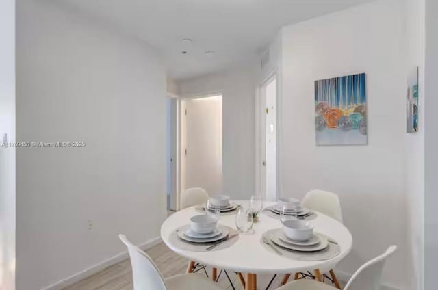 dining room featuring light wood finished floors and baseboards