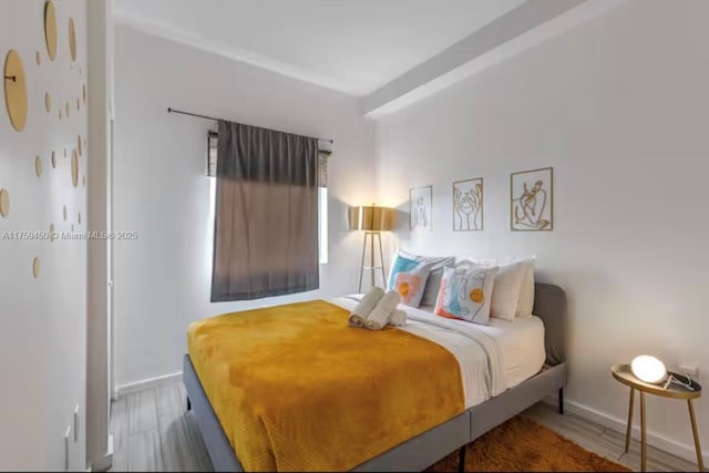 bedroom featuring baseboards and wood finished floors