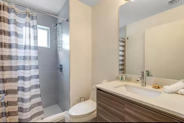 bathroom featuring toilet, vanity, visible vents, and a shower with shower curtain