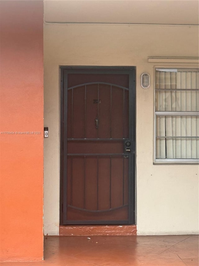 doorway to property featuring stucco siding