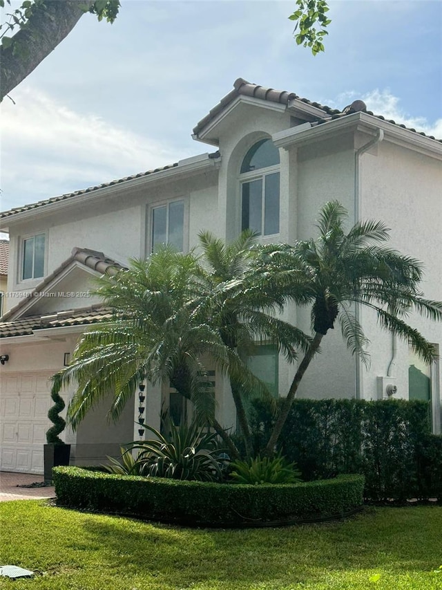 view of property exterior with a garage, a yard, and stucco siding