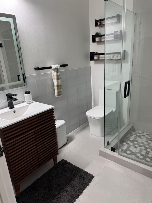 bathroom featuring tile walls, a shower stall, toilet, and vanity