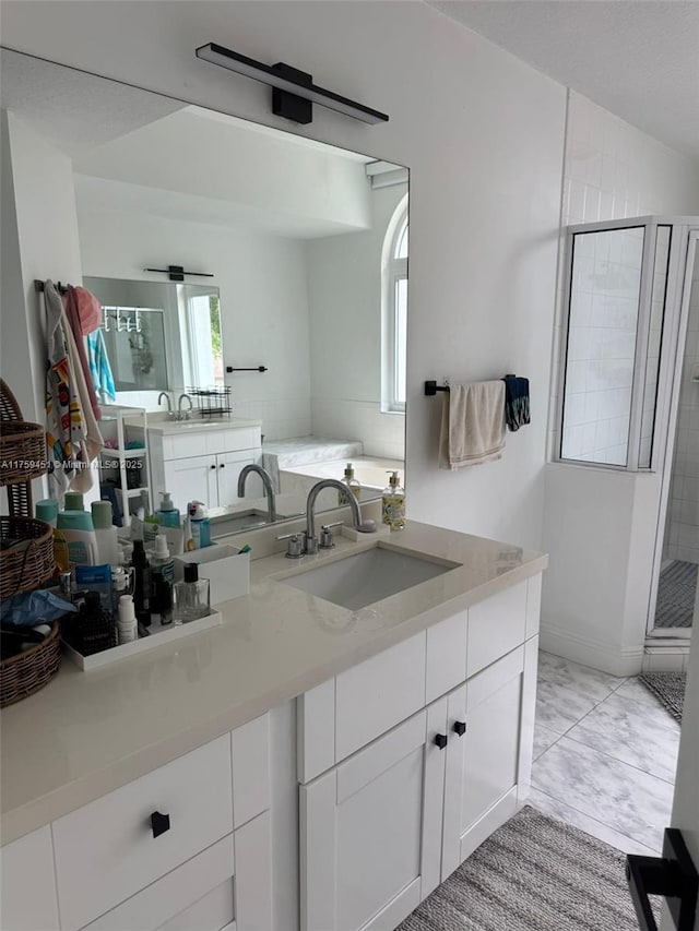 full bathroom featuring a stall shower, plenty of natural light, a garden tub, and vanity