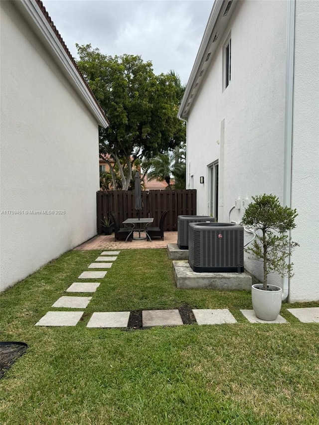 view of yard featuring a patio area, fence, and cooling unit