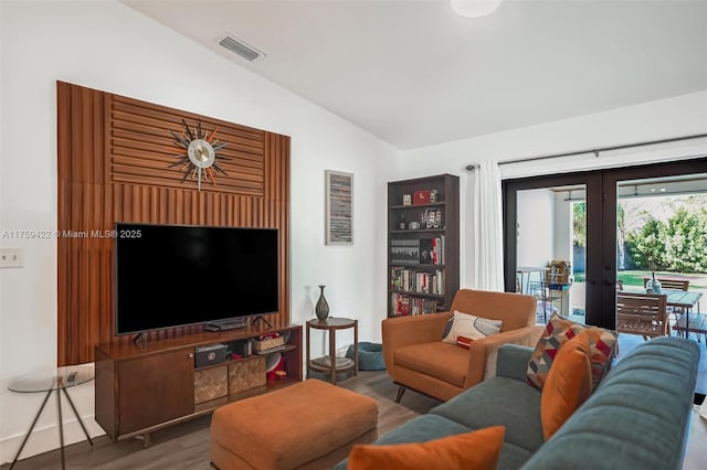 living room with vaulted ceiling, french doors, wood finished floors, and visible vents