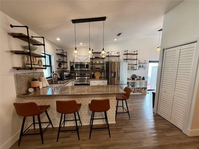 kitchen with stainless steel appliances, dark wood-style flooring, a peninsula, and open shelves