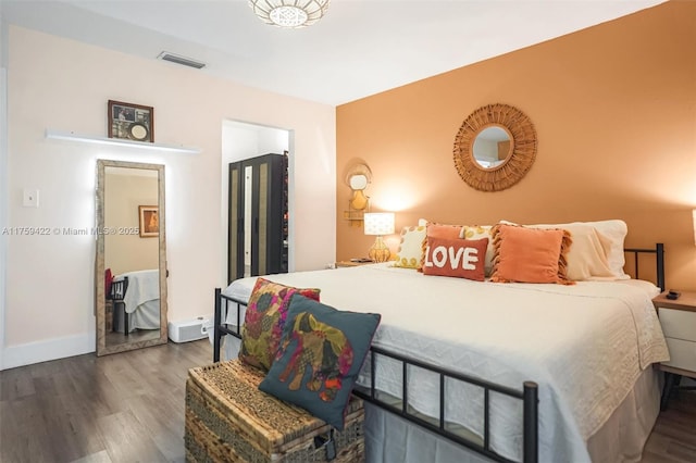 bedroom featuring visible vents, baseboards, and wood finished floors