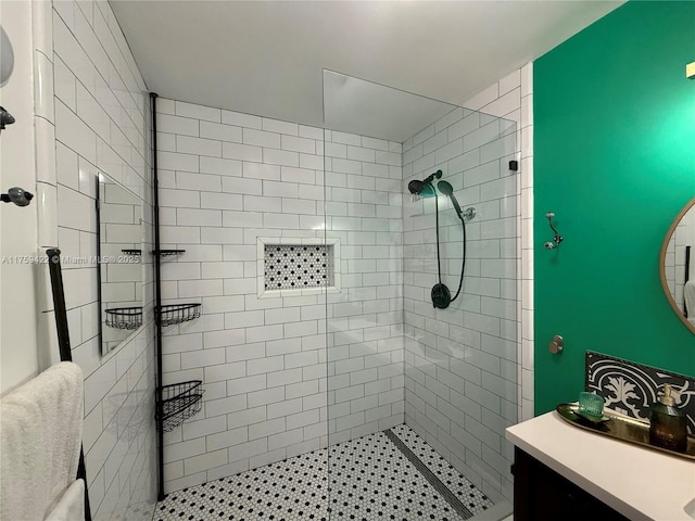 full bathroom featuring a tile shower and vanity