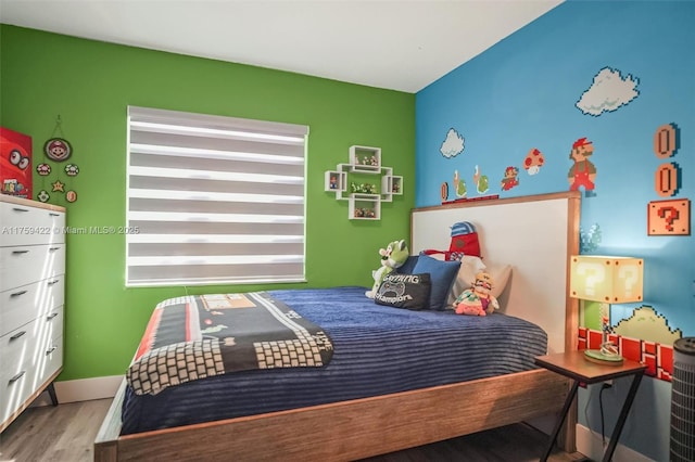 bedroom with baseboards and wood finished floors