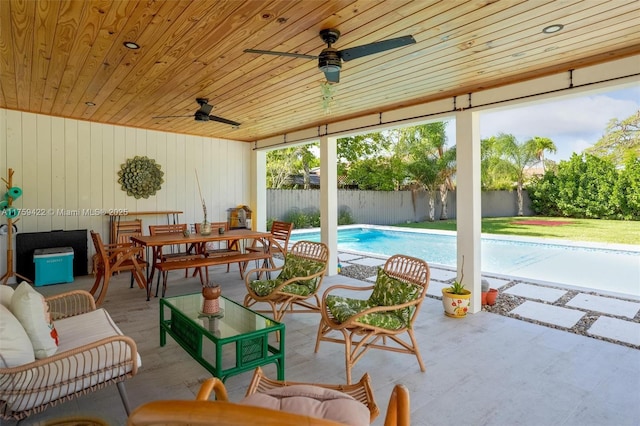 view of patio featuring a fenced in pool, outdoor dining space, fence, and a ceiling fan