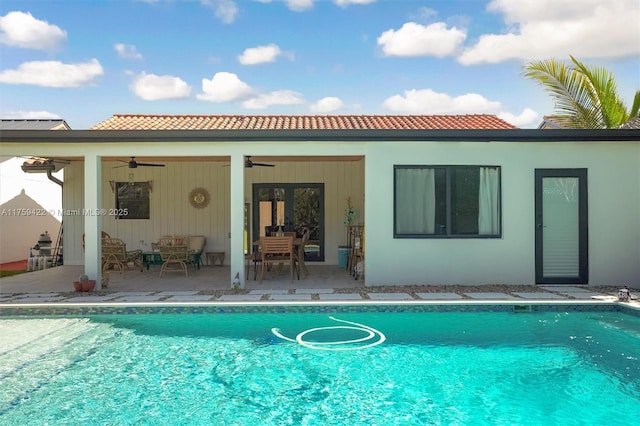 back of house featuring a ceiling fan, a patio area, and an outdoor pool