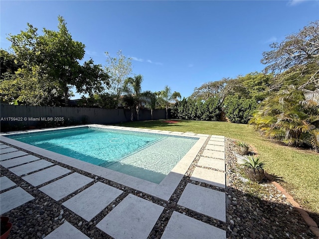 view of pool with a patio, fence, a fenced in pool, and a yard