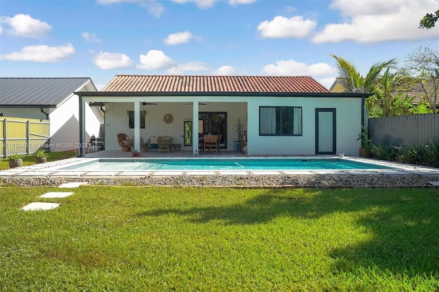 back of property featuring a ceiling fan, a patio area, fence, and a lawn