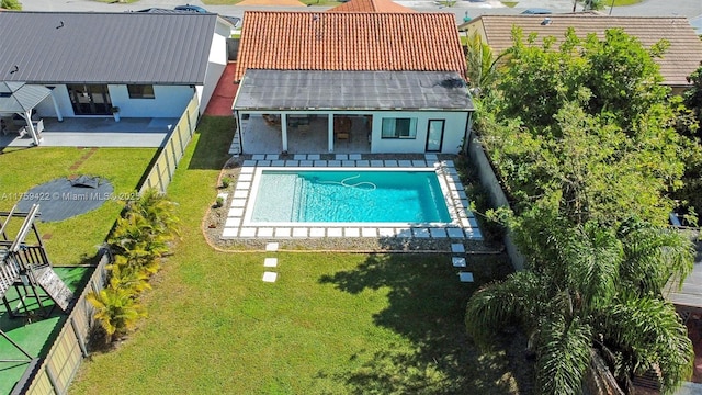 view of pool with a fenced in pool, an outbuilding, a yard, a patio area, and a fenced backyard