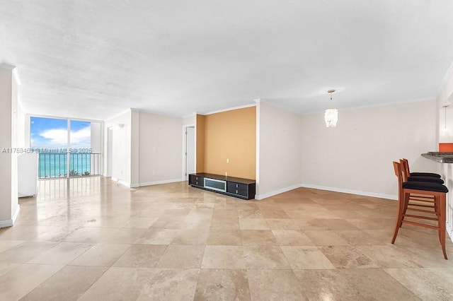 unfurnished living room featuring expansive windows, baseboards, and ornamental molding