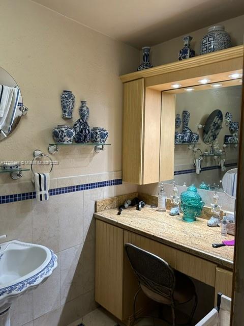 bathroom featuring a sink and tile walls