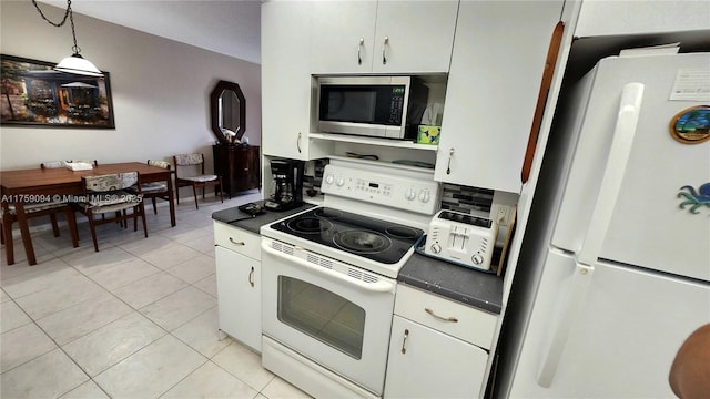 kitchen with dark countertops, white appliances, white cabinetry, and light tile patterned floors