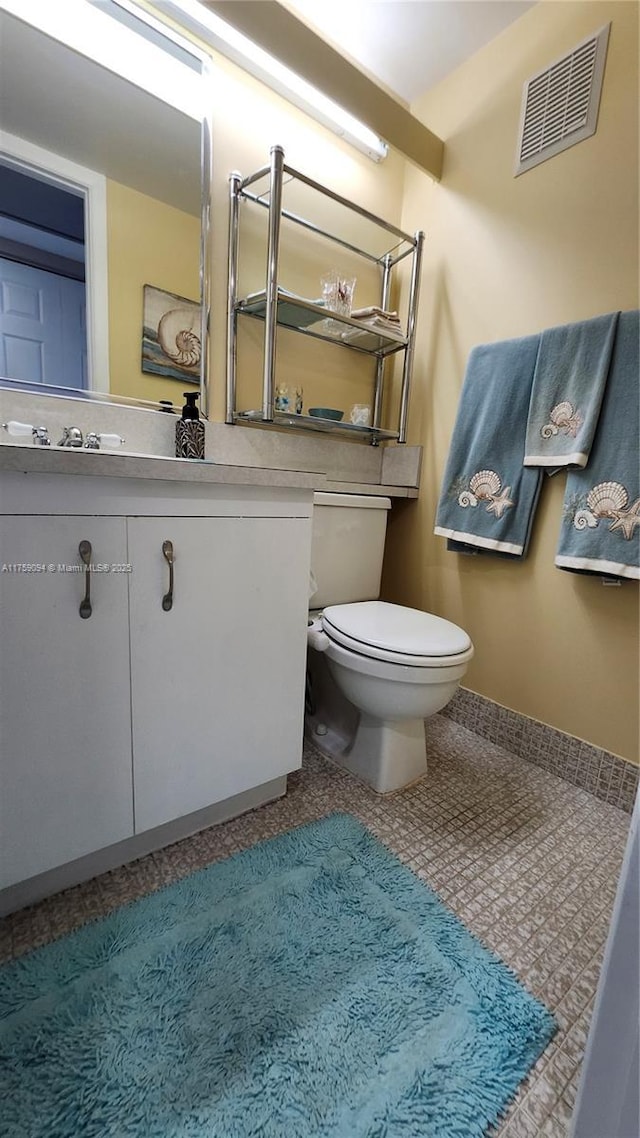 bathroom featuring toilet, tile patterned flooring, vanity, and visible vents