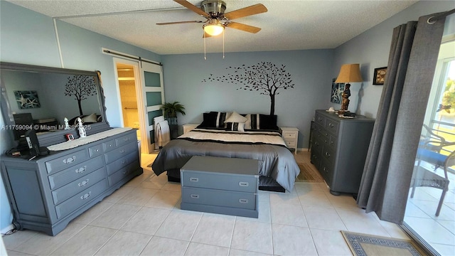 bedroom with light tile patterned floors, ceiling fan, a textured ceiling, and a barn door