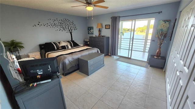 bedroom featuring a textured ceiling, ceiling fan, light tile patterned floors, and access to exterior