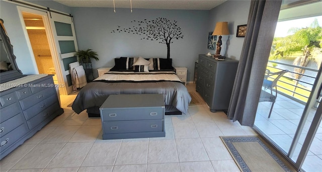 bedroom featuring light tile patterned floors and a barn door