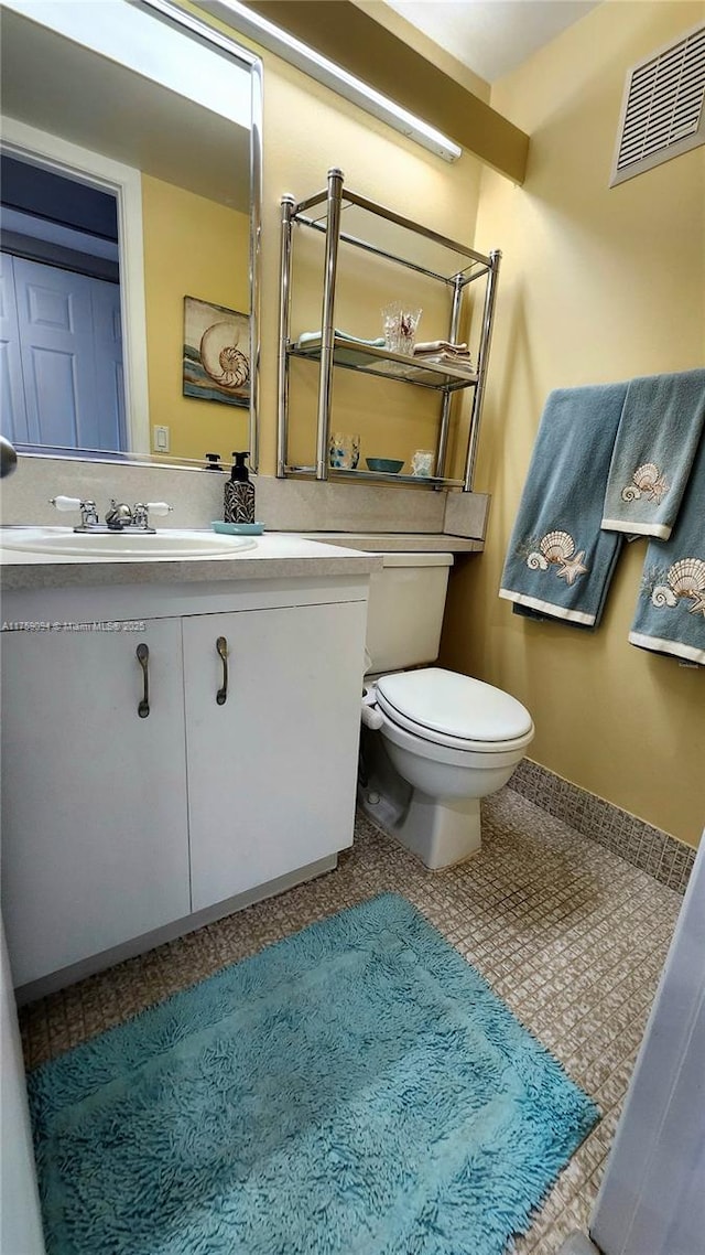 half bathroom with toilet, visible vents, and vanity