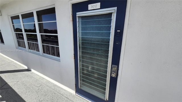 view of exterior entry featuring stucco siding