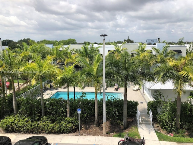 view of property's community featuring a swimming pool and fence
