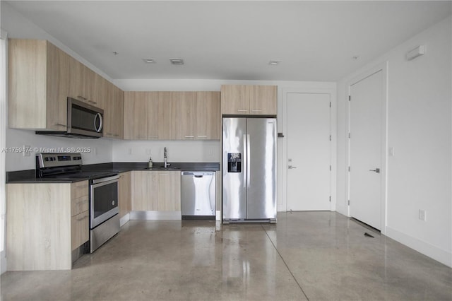 kitchen featuring modern cabinets, light brown cabinetry, dark countertops, and stainless steel appliances