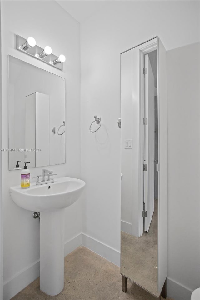 bathroom with a sink, baseboards, and speckled floor