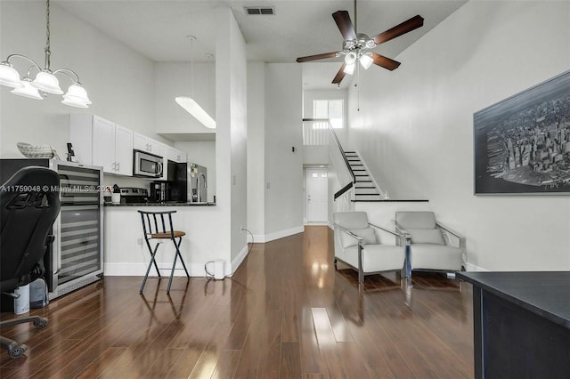 interior space featuring stairway, baseboards, visible vents, and dark wood-style flooring