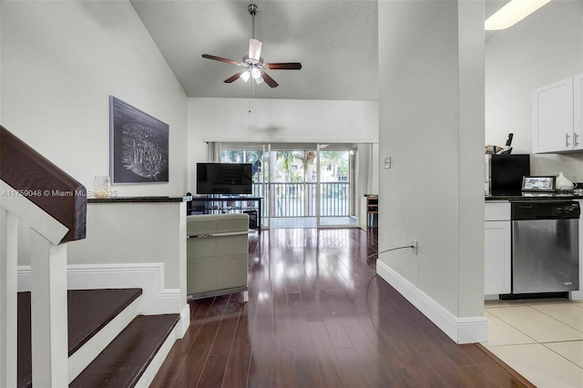 interior space featuring dishwasher, ceiling fan, wood finished floors, and white cabinetry