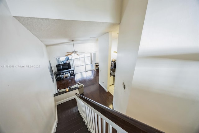 stairs with a textured ceiling, ceiling fan, wood finished floors, visible vents, and baseboards