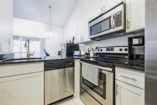 kitchen featuring white cabinetry, dark stone countertops, appliances with stainless steel finishes, and a sink