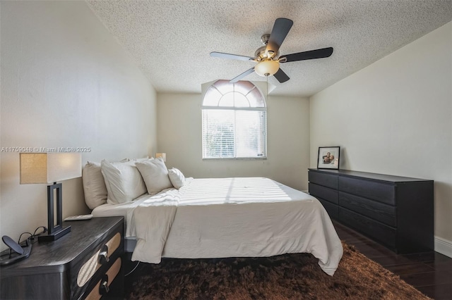 bedroom with a textured ceiling, ceiling fan, and wood finished floors