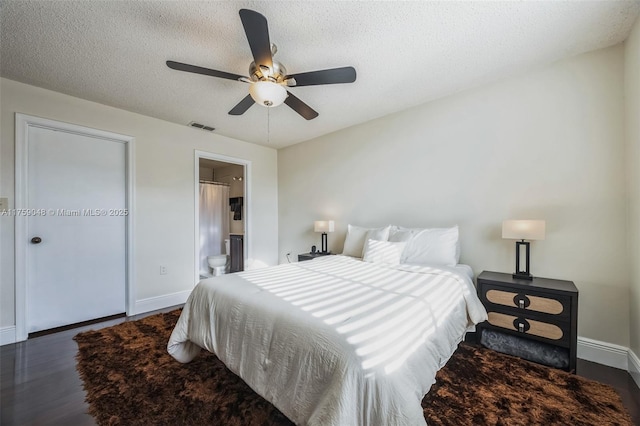 bedroom with visible vents, a ceiling fan, a textured ceiling, wood finished floors, and baseboards