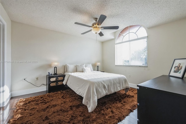 bedroom featuring a textured ceiling, ceiling fan, lofted ceiling, and baseboards