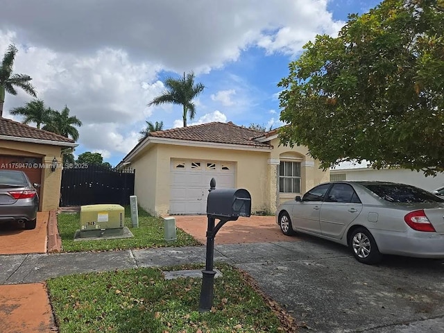 view of front of home featuring a garage, concrete driveway, a tiled roof, and stucco siding