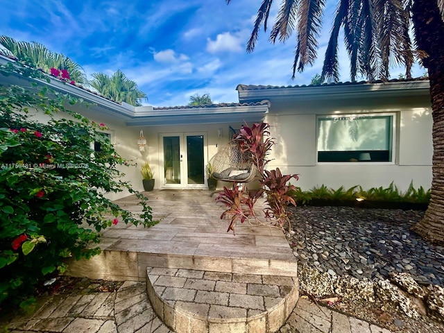 exterior space featuring stucco siding and french doors