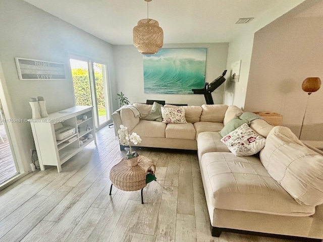 living area with visible vents and wood finished floors