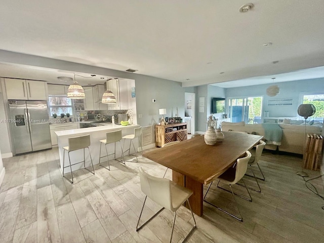 dining space featuring a healthy amount of sunlight and light wood-style flooring