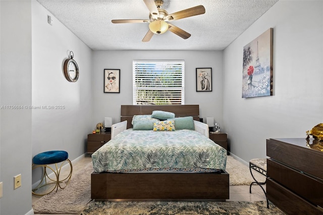 carpeted bedroom with a textured ceiling, a ceiling fan, and baseboards