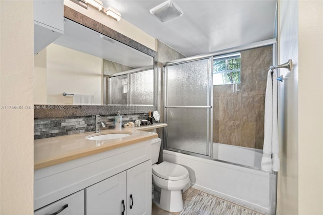 bathroom featuring toilet, shower / bath combination with glass door, vanity, and visible vents